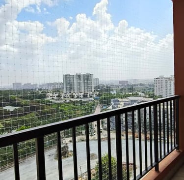 Close-up of a sturdy anti-pigeon net installed on a balcony railing in Adyar.