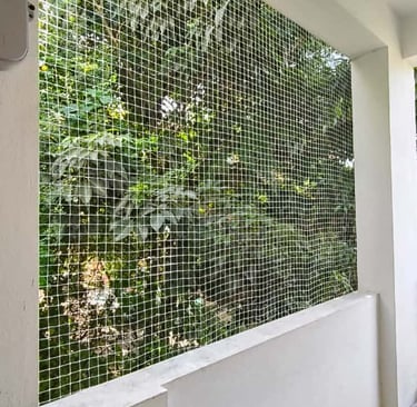 Evening view of a balcony with safety netting softly illuminated by warm indoor lights