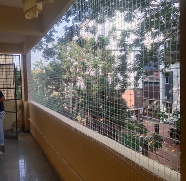 A securely netted balcony with sunlight filtering through, highlighting the netting’s strength and n