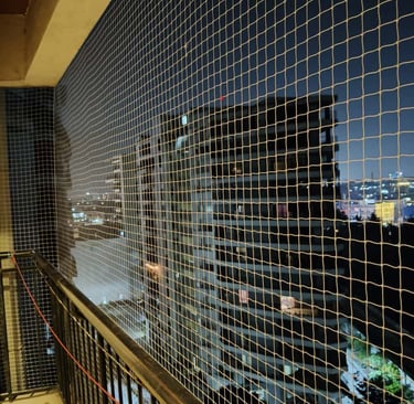 Close-up of durable anti-pigeon netting installed on a balcony in Koyambedu.