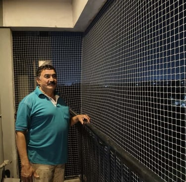 Installation team from Arjilli Enterprises fitting a staircase safety net with care and precision.