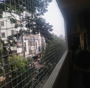Technician from Arjilli Enterprises carefully fixing a balcony safety net in Thiruvanmiyur