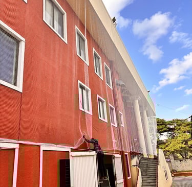 Wide shot of a high-rise balcony fully covered with durable pigeon netting against a blue sky.