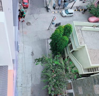 Wide shot of a high-rise apartment balcony fully covered with a protective net in Sholinganallur.