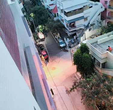 Installation process showing workers fitting anti-pigeon nets on a rooftop edge.