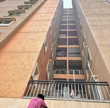 Close-up of a sturdy safety net installed around an apartment duct area in Chennai.