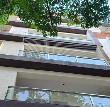 Close-up of a sleek invisible grill seamlessly blending with a balcony railing in Alwarpet.