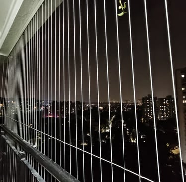 Evening shot of a balcony with gentle lighting, showcasing the protective bird net that keeps pigeon