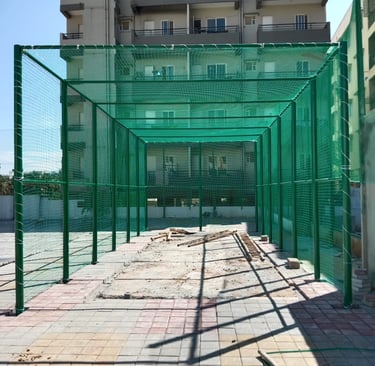 Technician from Arjilli Enterprises carefully securing a net around a basketball court fence