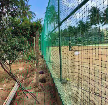 Terrace top nets casting shadows over a quiet home practice area in the evening light.