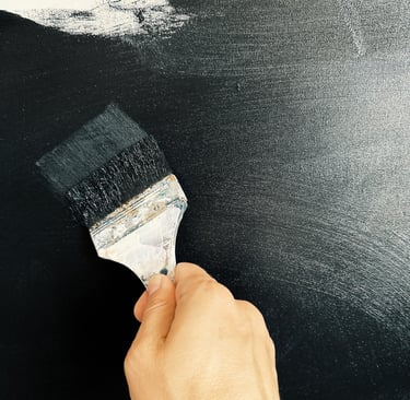 man’s hand holding a brush is painting