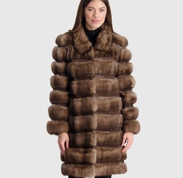 a woman in a long brown gorski coat with a fur coat