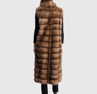 a woman wearing a long, brown gorski fur vest