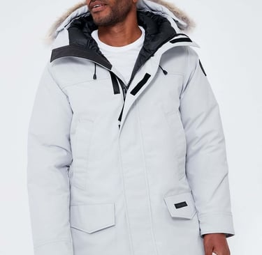 a man wearing a white jacket and grey pants