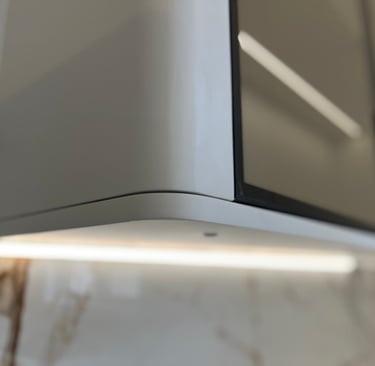 Modern kitchen cabinet with rounded corners and integrated LED under-cabinet lighting.