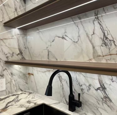 Modern marble kitchen backsplash with floating wooden shelves and integrated LED lighting.