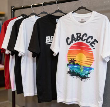Colorful custom-printed t-shirts hanging on a rack, showcasing unique logos and messages.