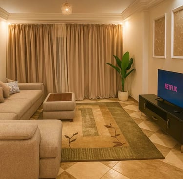 Modern living room with a beige sectional sofa, patterned area rug, and smart TV displaying Netflix.