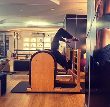 Pilates practioner performing advanced spine extension on ladder barrel at The Pilates Room Bangsar