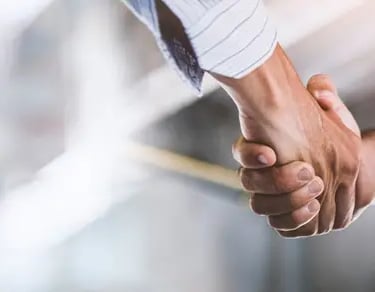 une poignée de main entre le maitre d'ouvrage et l'assistant à maitrise d'oeuvre