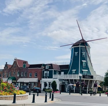 Historic Dutch windmill building and storefronts in a charming downtown village street.