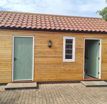 Exterior of a single storey building, with the front covered in wooden panelling.