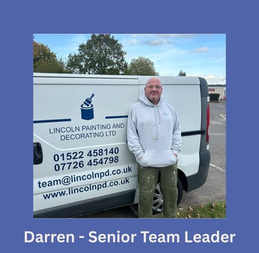 Portrait of Darren, a senior team leader, smiling and standing next to his branded van.