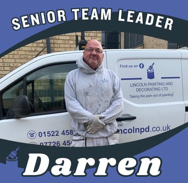 Portrait of Darren, a senior team leader, smiling and standing next to his branded van.