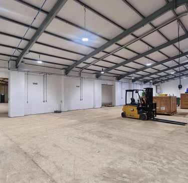 A large hall room in a warehouse, with freshly white painted walls.