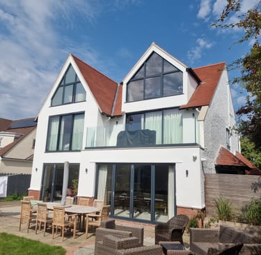 Exterior front of a painted-white, 3-storey residential home, with black-detailed windows/doors.