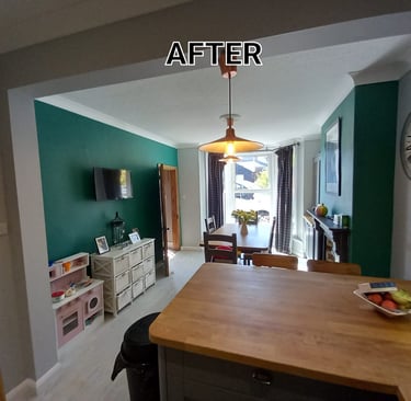 Open kitchen/dining room, with wood table, wood kitchen island, white ceiling, and emerald walls.