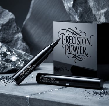 Black liquid eyeliner pen with felt tip applicator displayed against a luxury slate and rock background.