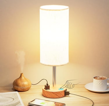 Modern touch control table lamp with wooden base, USB charging ports, and fabric shade on a desk.