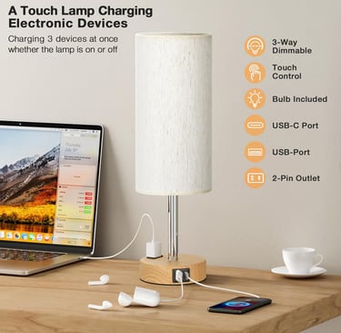 Dimmable touch bedside lamp with USB-C and USB ports charging a smartphone and laptop on a desk.