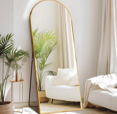 Gold arched full length floor mirror leaning against a white wall in a modern living room.