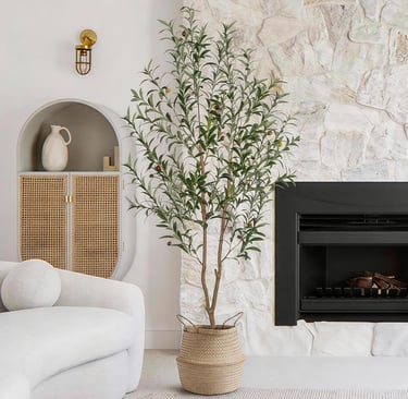6FT artificial olive tree styled in a cozy living room beside a fireplace