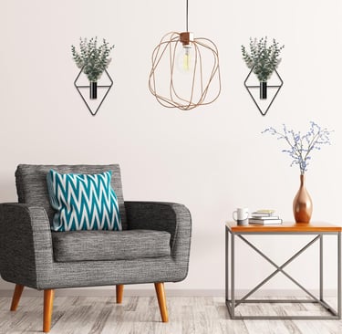 Modern living room featuring geometric wall planters with eucalyptus and a copper wire pendant light.