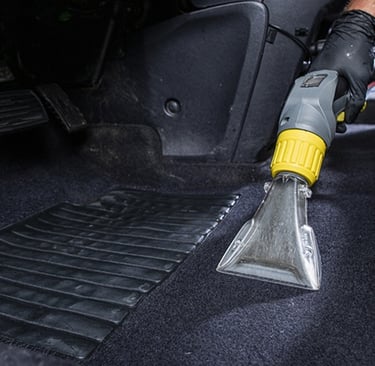 a person cleaning a car with a vacuum