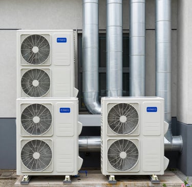 A friendly technician speaking with a homeowner beside a clean HVAC system.