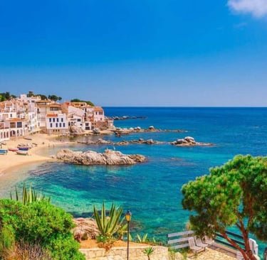 Scenic view of Calella de Palafrugell coastal village on Costa Brava with turquoise water and white houses.