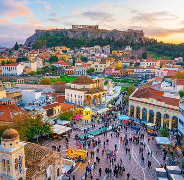 Aerial view of Monastiraki Square in Athens, Greece with the Acropolis and Parthenon at sunset.