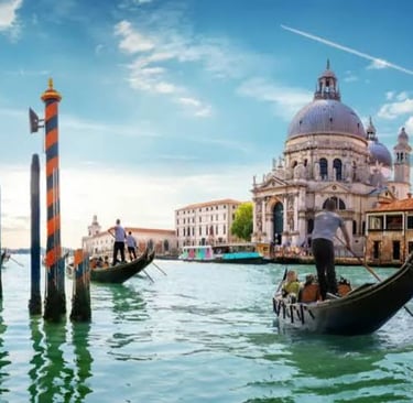 Gondolas cruising the Grand Canal past the historic Santa Maria della Salute basilica in Venice, Italy.