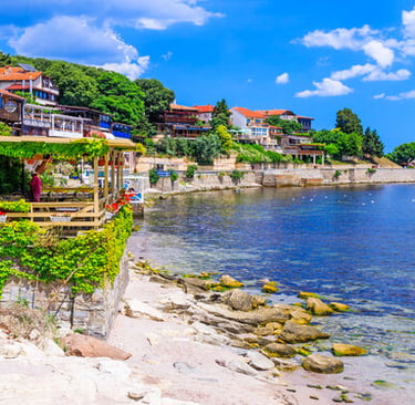 Scenic seaside view of Nessebar Old Town in Bulgaria with waterfront restaurants and blue Black Sea coast.