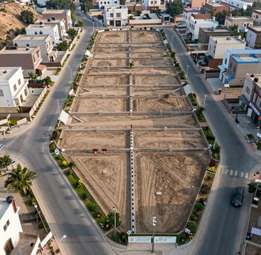 Plot of land with clear boundaries and green grass in a developing area.
