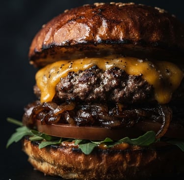 Tight macro shot of a gourmet burger with melting cheddar cheese and caramelized onions on a dark artisanal brioche bun, moody side lighting, rich charcoal background, warm amber highlights