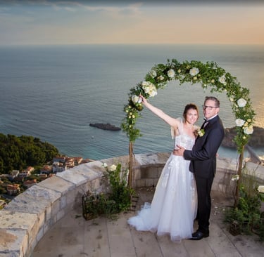 Sunset wedding ceremony Sveti Stefan Perast - Bride groom at flower arch clifftop Adriatic Sea Boka Bay Montenegro