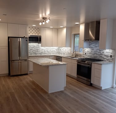 Modern kitchen remodel featuring white shaker cabinets, and stainless steel appliances.