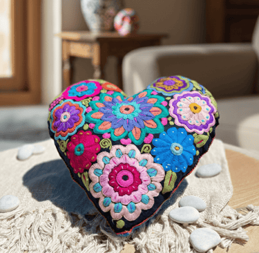 Handmade heart-shaped pillow featuring vibrant Mexican embroidery and colorful floral patterns.