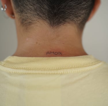 Tatuaje fineline en Madrid con lettering AMOR en mayúsculas en la nuca