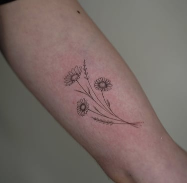 Tatuaje fineline en Madrid de tres amapolas con tallo largo y pétalos finos en composición botánica 